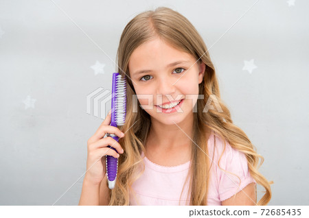 Girl long curly hair grey interior background. Child curly Girl long curly hair grey interior background. Child curly 72685435