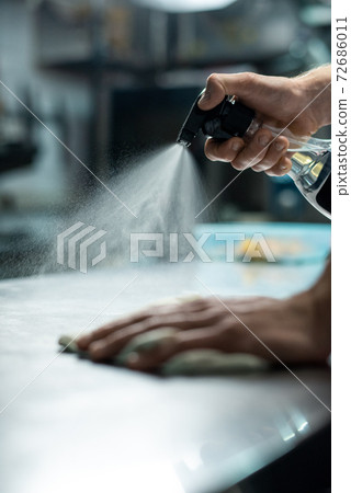 Hands of contemporary worker of restaurant kitchen spraying sanitizer on table Hands of contemporary worker of restaurant kitchen spraying sanitizer on table 72686011