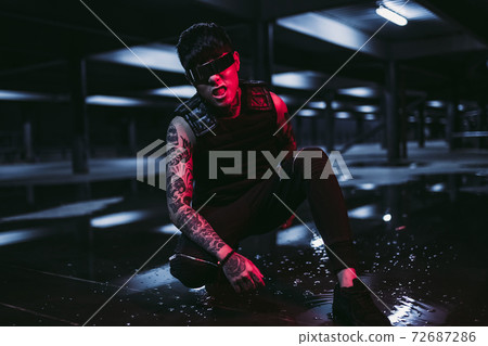 Man in the night city. Portrait of a man with Asian appearance in a neon city. Man in the night city. Portrait of a man with Asian appearance in a neon city. 72687286