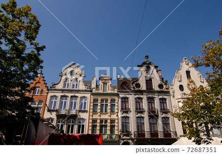 Mechelen, Belgium, August 2019. In the historic center, the shopping street, the beautiful facades of the historic buildings frame the brand shops. Beautiful sunny summer day. Mechelen, Belgium, August 2019. In the historic center, the shopping street, the beautiful facades of the historic buildings frame the brand shops. Beautiful sunny summer day. 72687351