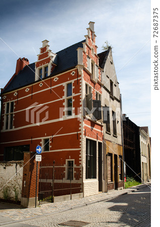 Mechelen, belgium, august 2019. A house with typical local architecture, perfectly restored with bright colors. Adjacent another in poor condition 72687375