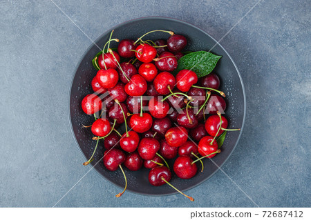 Cherry with leaf on plate and water dropsand on grey stone table Cherry with leaf on plate and water dropsand on grey stone table 72687412
