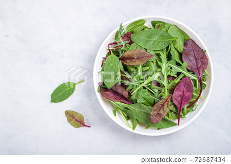 Healthy salad, leaves mix salad of spinach, arugula, lettuce in white plate on grey table . 72687434
