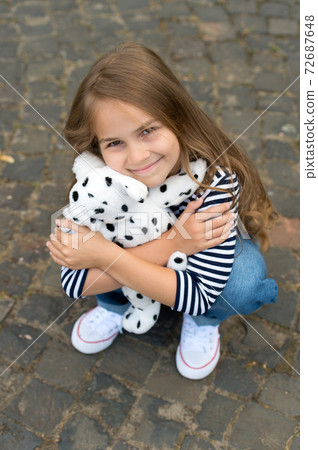 Moments of play. Happy child cuddle toy dog outdoors. Moments of play. Happy child cuddle toy dog outdoors. 72687648