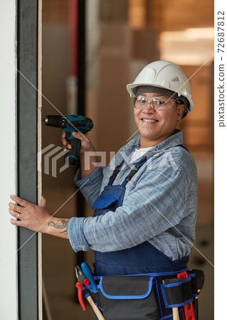 Smiling Woman Enjoying Work at Construction Site 72687812