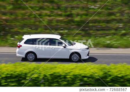 A panning shot of a running car Corolla Fielder A panning shot of a running car Corolla Fielder 72688567