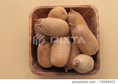 Small kiwifruit in a wooden bowl 72688823