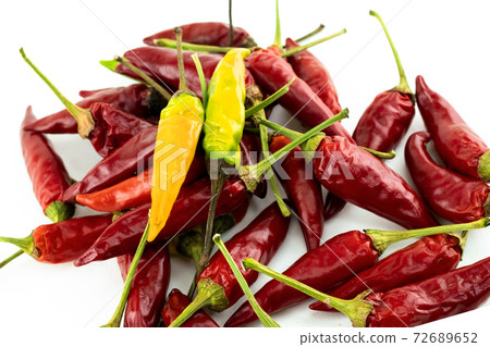 yellow chili pepper is on top of a scattering of peppers yellow chili pepper is on top of a scattering of peppers 72689652
