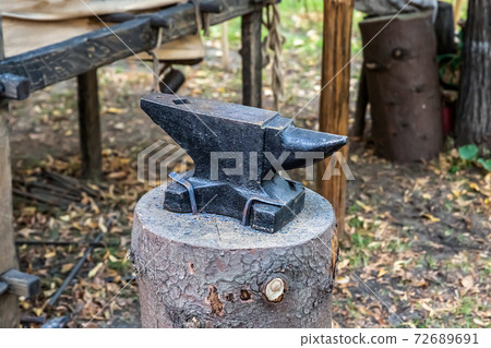 iron black anvil on the stump piece of forge equipment 72689691