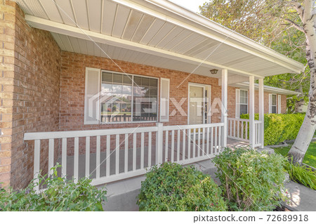 Front porch and garden of traditional brick home Front porch and garden of traditional brick home 72689918