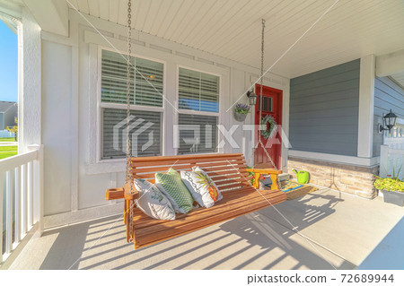 Swinging chair on porch of traditional town house Swinging chair on porch of traditional town house 72689944