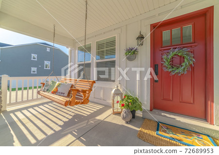 Front porch of alternative home and swinging chair Front porch of alternative home and swinging chair 72689953