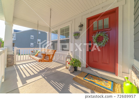 Front porch of modern home with swinging chair Front porch of modern home with swinging chair 72689957