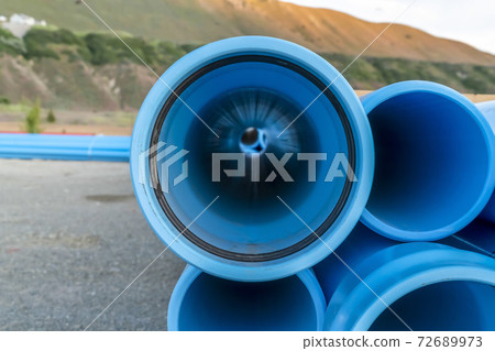 Close up of the holes of light blue pipes at a construction area on a sunny day Close up of the holes of light blue pipes at a construction area on a sunny day 72689973