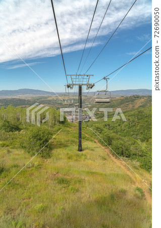 Focus on chairlifts against mountain sky and clouds in Park City at off season Focus on chairlifts against mountain sky and clouds in Park City at off season 72690050