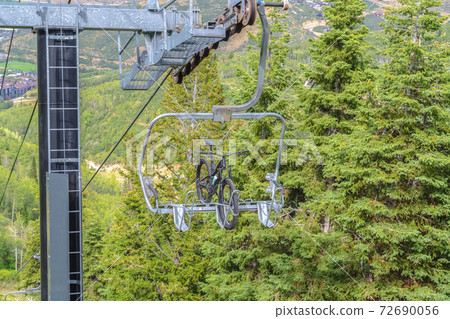 Mountain bike on a lift against trees in Park City ski resort during off season Mountain bike on a lift against trees in Park City ski resort during off season 72690056