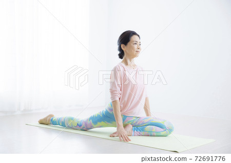 A woman in her 50s doing yoga A woman in her 50s doing yoga 72691776