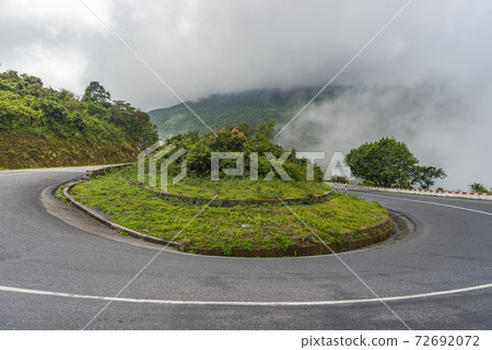 Cloudy and misty sky on horseshoe road curve on mountain Cloudy and misty sky on horseshoe road curve on mountain 72692072