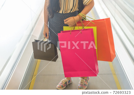 Young girl holding many colorful shopping bags Young girl holding many colorful shopping bags 72693323