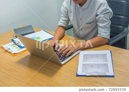 Asian businessman hand typing laptop next to Asian businessman hand typing laptop next to 72693539