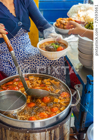 Woman cooking Vietnamese Bun Rieu noodle at street food vendor 72693661
