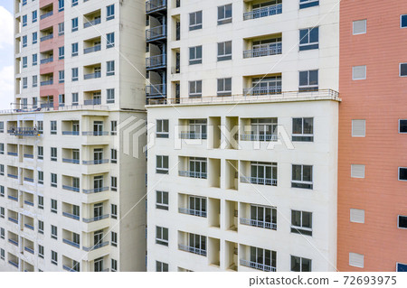Facade of apartment building with balconies and windows 72693975
