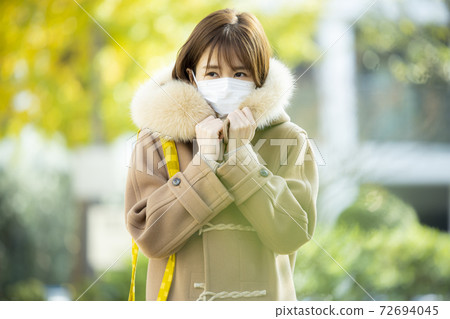 Woman in coat and mask Woman in coat and mask 72694045