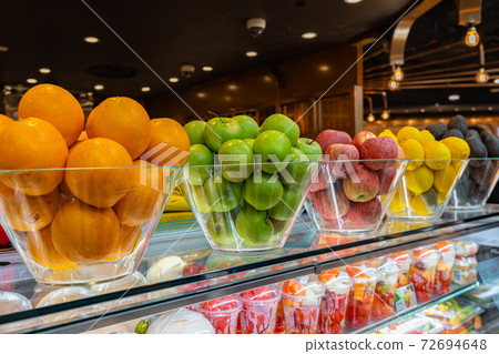 Assortment of fresh fruits in glass bowls in restaurant 72694648