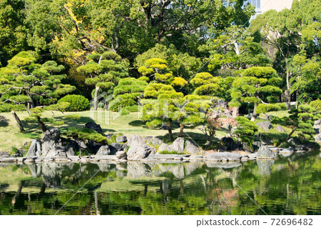 Kiyosumi Garden, Koto Ward, Tokyo: A large spring and stepping stones overlooking the rocks. A designated place of scenic beauty by the Tokyo Metropolitan Government. Kiyosumi Garden, Koto Ward, Tokyo: A large spring and stepping stones overlooking the rocks. A designated place of scenic beauty by the Tokyo Metropolitan Government. 72696482