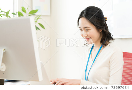 一名年輕女子走向一台電腦 72697684