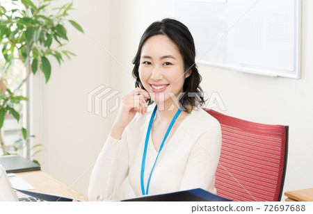 一名年輕女子走向一台電腦 72697688