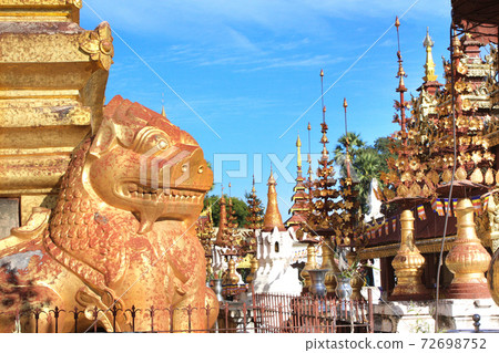Golden statue of lion guardian and stupas, Bagan, Myanmar Golden statue of lion guardian and stupas, Bagan, Myanmar 72698752