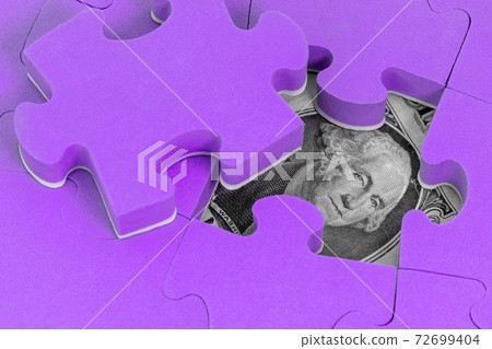 US dollar banknote hidden under purple puzzle 72699404