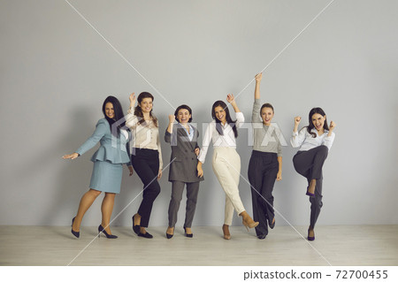 Team of happy young businesswomen celebrating their success, cheering and smiling 72700455