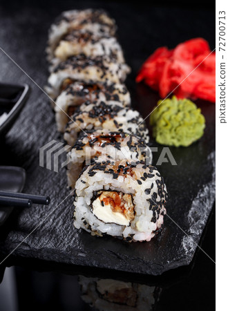 Japanese sushi on a dark stone background. Sushi set with ginger, wasabi and soy sauce. Serve with chopsticks. Japanese sushi on a dark stone background. Sushi set with ginger, wasabi and soy sauce. Serve with chopsticks. 72700713