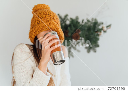 Woman in orange hat and metal reusable termo mug on christmas winter day. Sustainable living Woman in orange hat and metal reusable termo mug on christmas winter day. Sustainable living 72701590