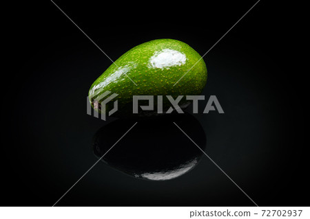 green fresh avocado over black background close-up 72702937