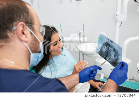 people, medicine, stomatology and health care concept - happy male dentist showing work plan to woman patient at dental clinic office people, medicine, stomatology and health care concept - happy male dentist showing work plan to woman patient at dental clinic office 72703044
