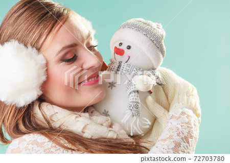 Smiling cute woman with little snowman. Winter. 72703780