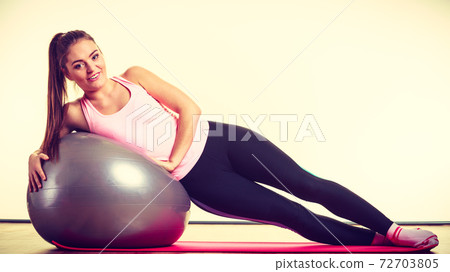 Girl exercising with fit ball Girl exercising with fit ball 72703805