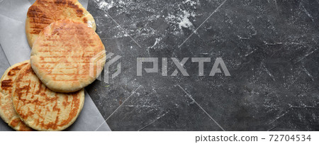 Round pita bread. Dark background. Place for text. Copyspace Round pita bread. Dark background. Place for text. Copyspace 72704534