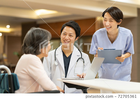 Doctor to see and senior woman in a wheelchair 72705361