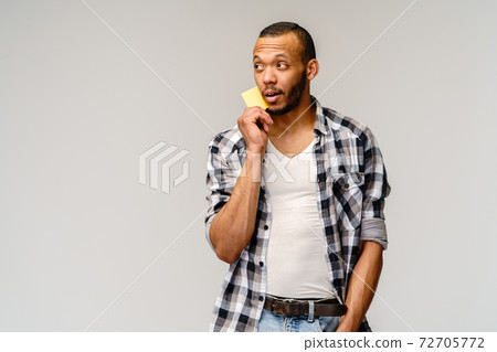 Happy young african american man holding cash or discount card 72705772