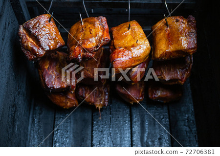 Close up of a smoked meat and belly or beech meat with dark crust in the smokehouse or smoker, food concept 72706381