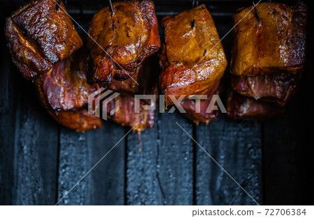 Close up of a smoked meat and belly or beech meat with dark crust in the smokehouse or smoker, food concept 72706384