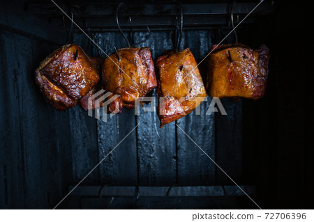 Close up of a smoked meat and belly or beech meat with dark crust in the smokehouse or smoker, food concept 72706396