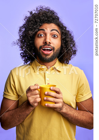 emotional arabic male with cup in hands 72707010