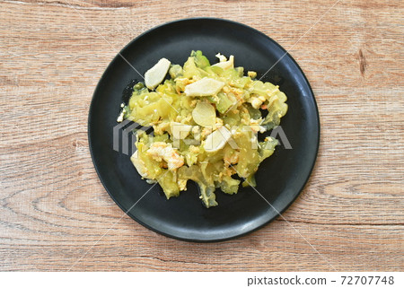 stir fried bitter cucumber with egg and slice garlic on plate stir fried bitter cucumber with egg and slice garlic on plate 72707748