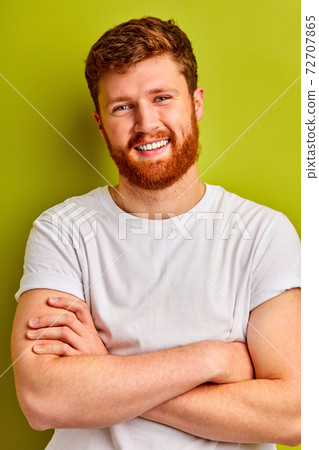 studio shoot of caucasian guy with beard standing with crossed arms smiling 72707865
