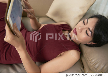 Woman resting with digital tablet Woman resting with digital tablet 72708012